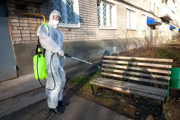 exterminateur arrosant un banc de produit anti cafards